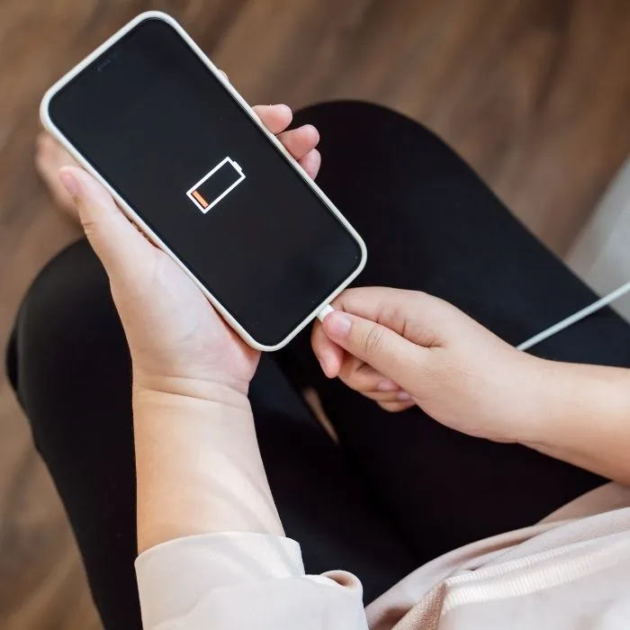 Persona cargando la batería del celular