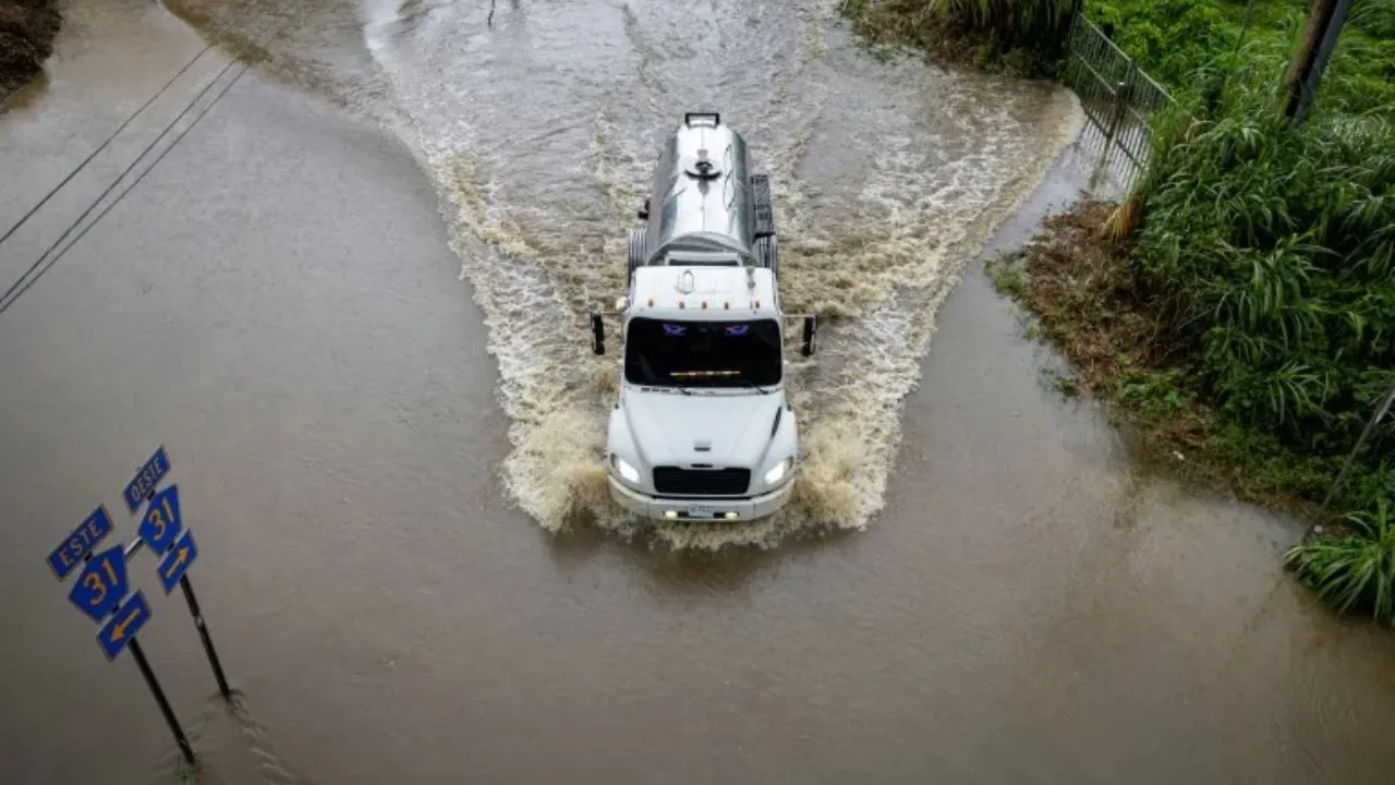 Camión avanza por una carretera inundada en Naguabo, Puerto Rico, por el huracán Erin.
