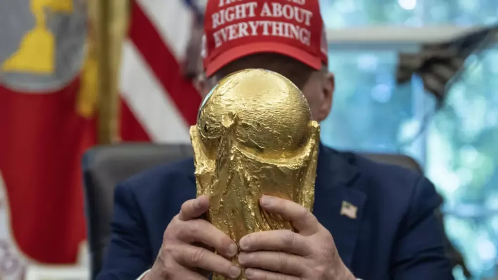 Donald Trump tocando el trofeo de la Copa Mundial del Fútbol