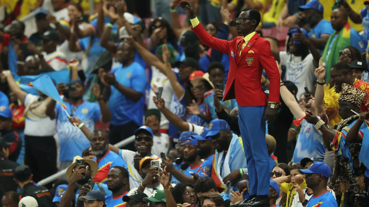 Michel Kuka Mboladinga, 'Lumumba Vea', en la tribuna durante Colombia vs. RD del Congo. ¿Brujería en el Mundial? Esto se sabe de la extraña pose del hincha de RD del Congo viral en redes